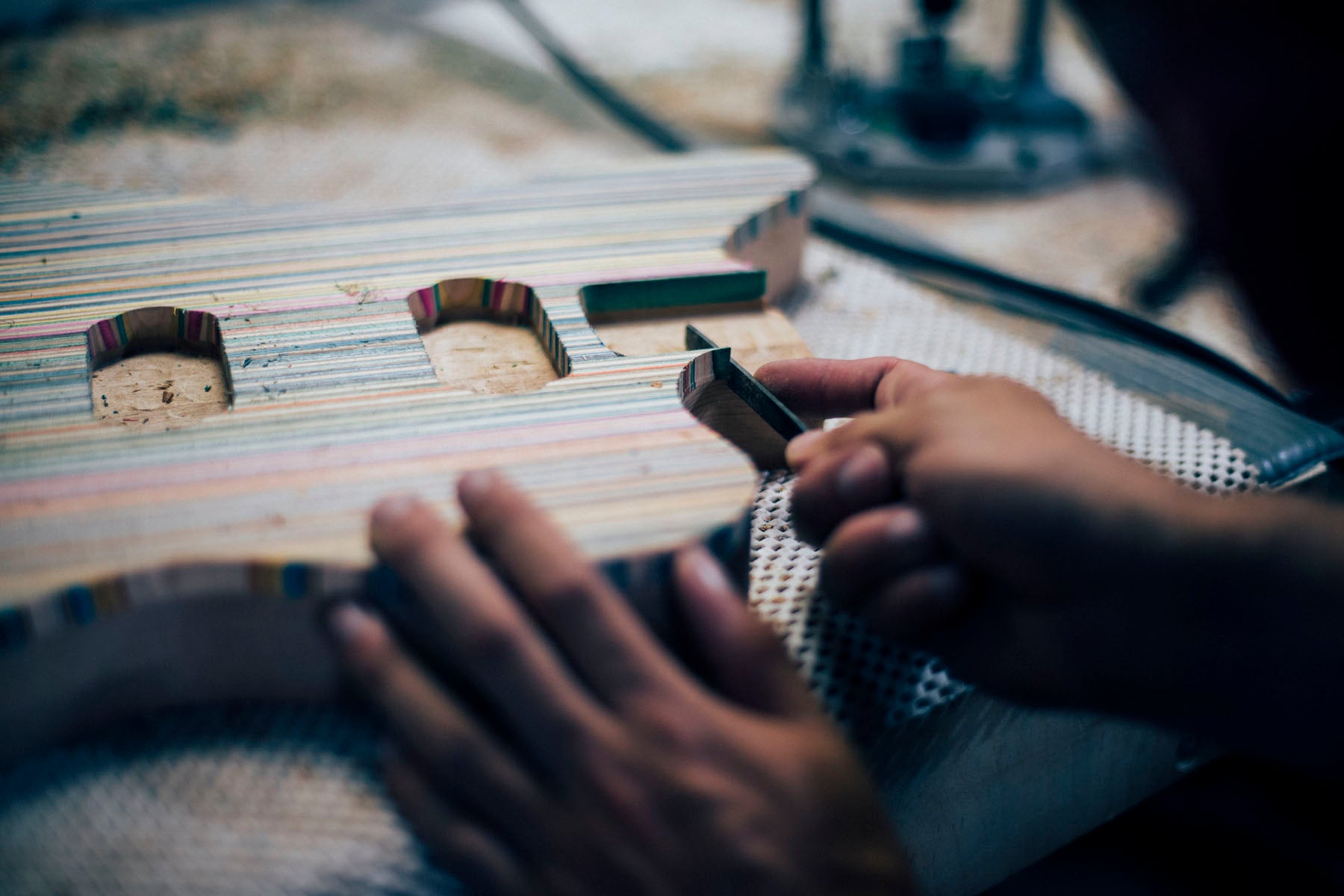 Filing bookmatched skateboard wood on a guitar body